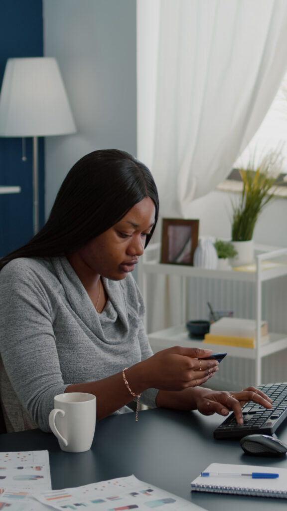 The Lifestyle Habits of Financially Successful Nigerians 12 young woman holding electronic credit card typing online payment computer keyboard while ordering electronic tablet online sale