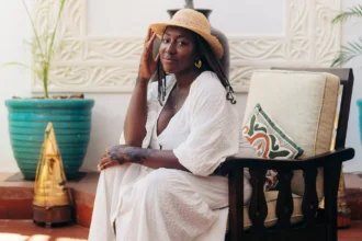 Solo female traveler wearing a white dress and straw hat, relaxing at a boutique hotel in Zanzibar during a safe and stylish solo vacation.