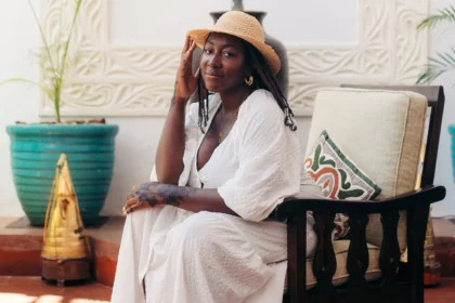 Solo female traveler wearing a white dress and straw hat, relaxing at a boutique hotel in Zanzibar during a safe and stylish solo vacation.