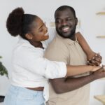 Smiling couple embracing at home, symbolizing healing, forgiveness, and rebuilding trust after relationship betrayal.